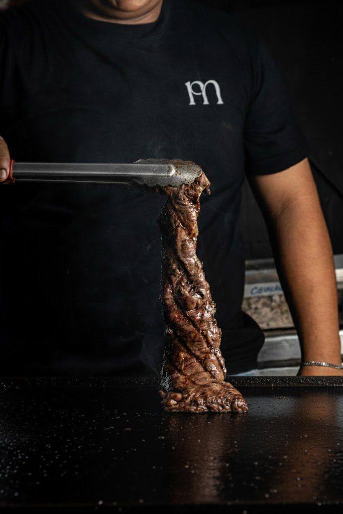 Corte de carne a la parrilla servido con pinzas