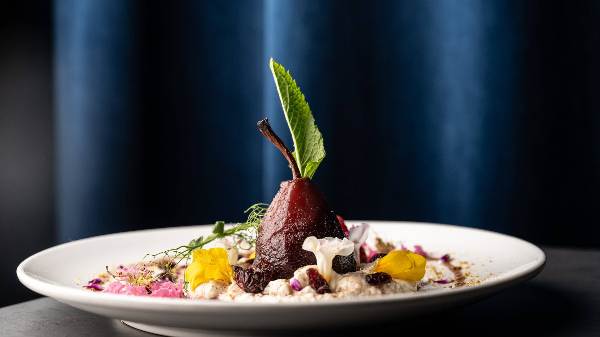Plato de autor con pera, flores comestibles y crema